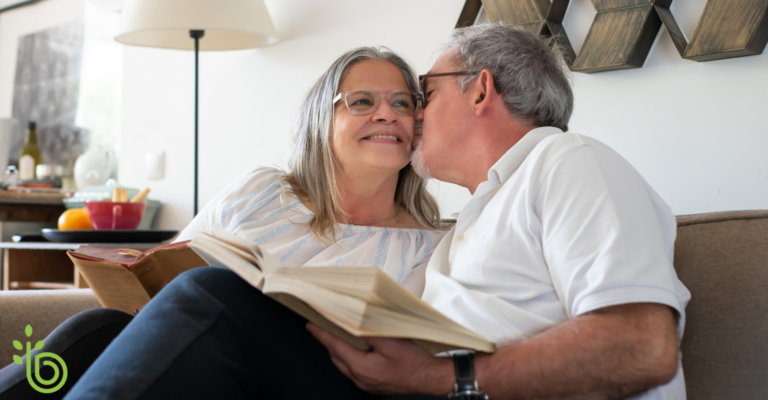 Empty nesters sitting happily on a couch reading books