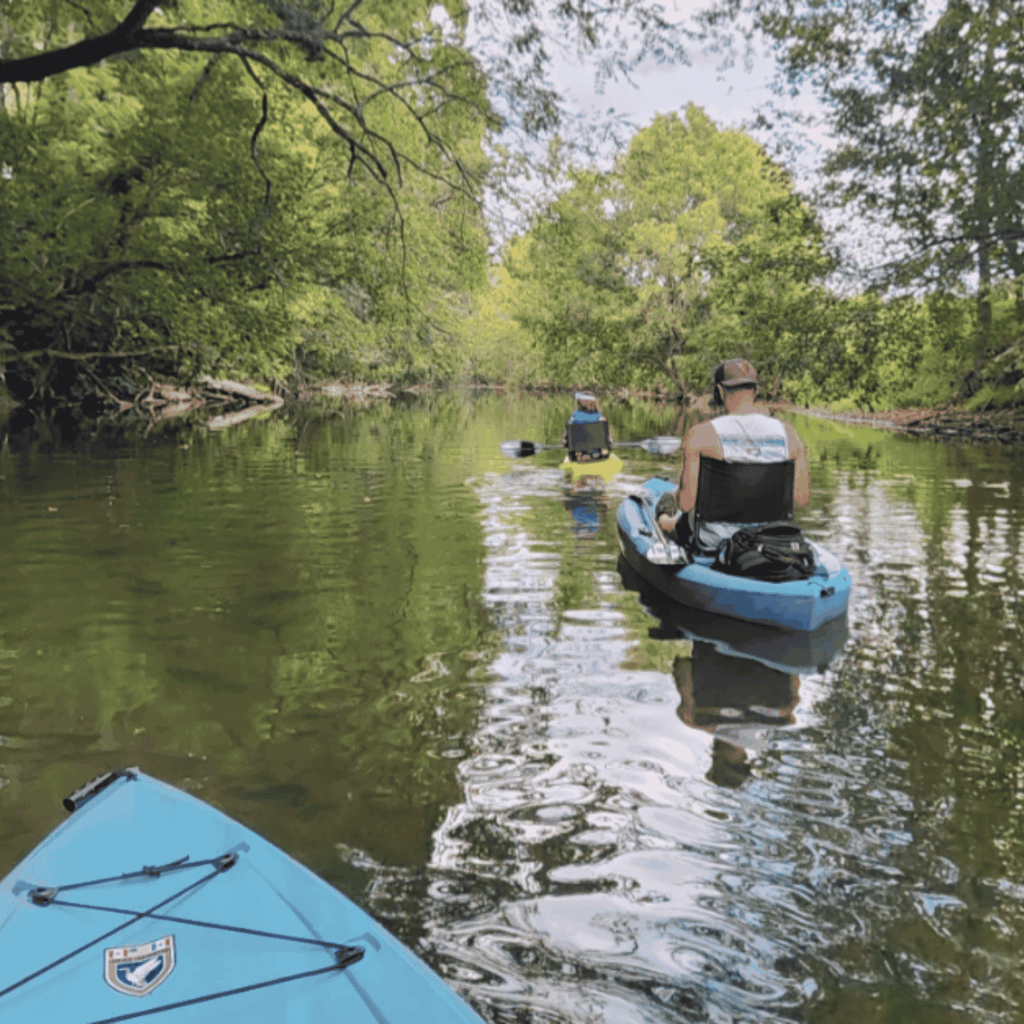 Kassi Redifer’s husband and daughter kayaking along Middle River in Virginia, surrounded by trees and peaceful countryside.