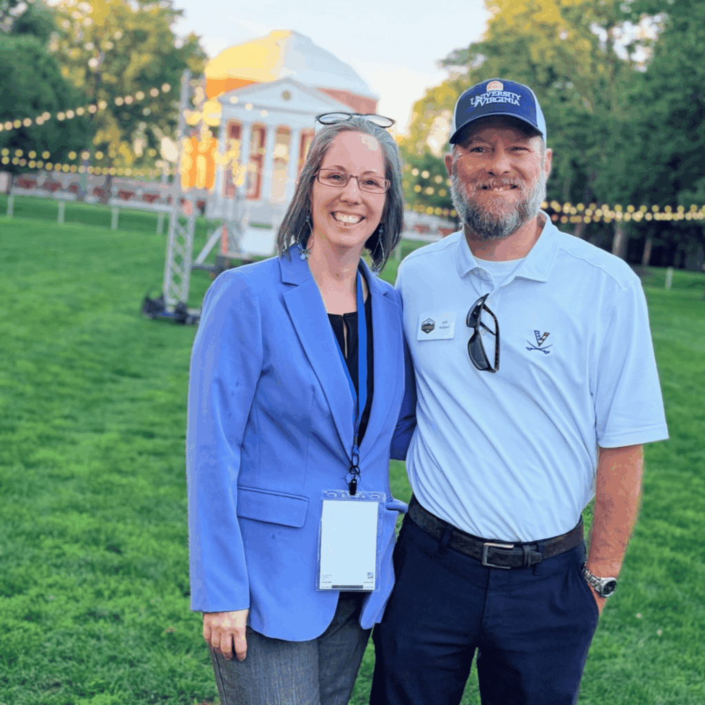 Marcy and Jeff Holbert smiling together on the University of Virginia Lawn in Charlottesville, with the Rotunda in the background.