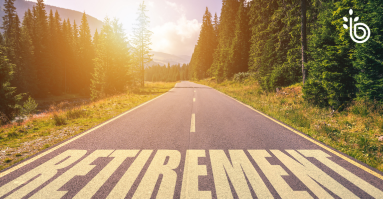 Mountain road leading toward the horizon with the word “RETIREMENT” painted on the pavement, symbolizing the critical five years before retirement planning.